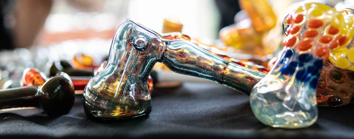 A closeup of a glass pipe is shown with others behind it.