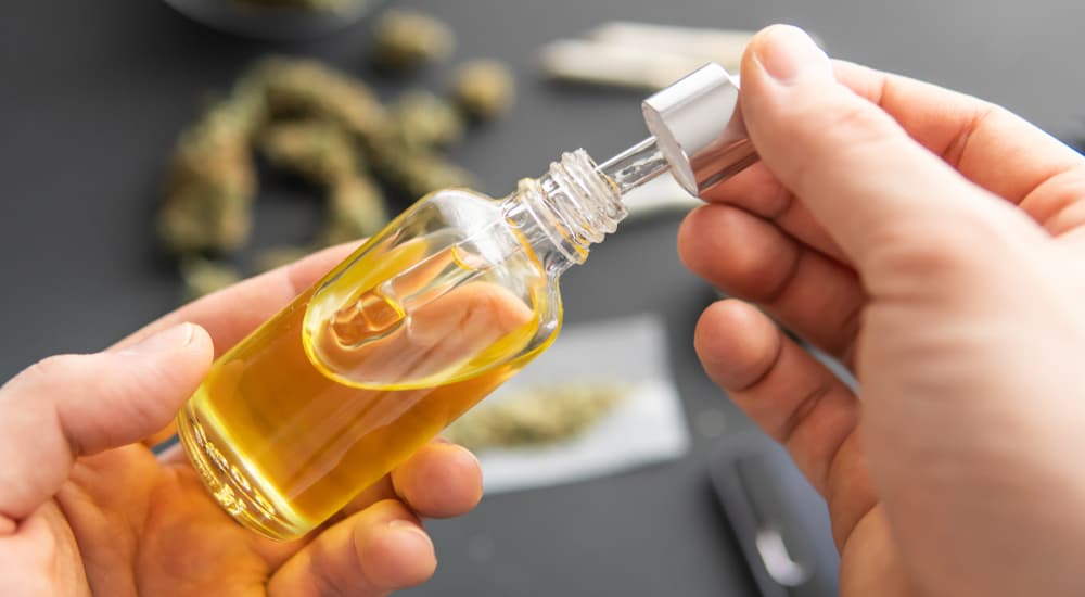 THC oil in a dropper bottle is being held by a person about to make hash.